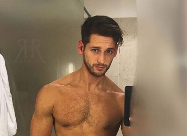 Max Emerson, a male underwear model, takes a selfie in the mirror. He is shirtless and has tossed brown hair.
