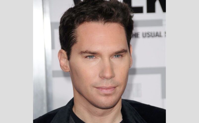 Director Bryan Singer at a movie event. He has black hair, a chiseled face, and a serious expression. He is wearing a black shirt.