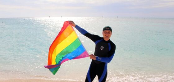 This sexy travel guru lives in a van and is literally planting the rainbow flag everywhere he goes
