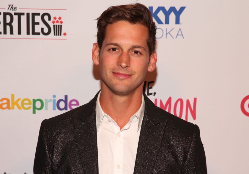 Underwear model Max Emerson smooths out his penis line: Max Emerson smiles at the camera at a charity event. He is wearing a nice suit and has brown hair and brown eyes.