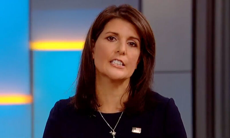Nikki Haley wearing a dark coat with an American flag pin. 
