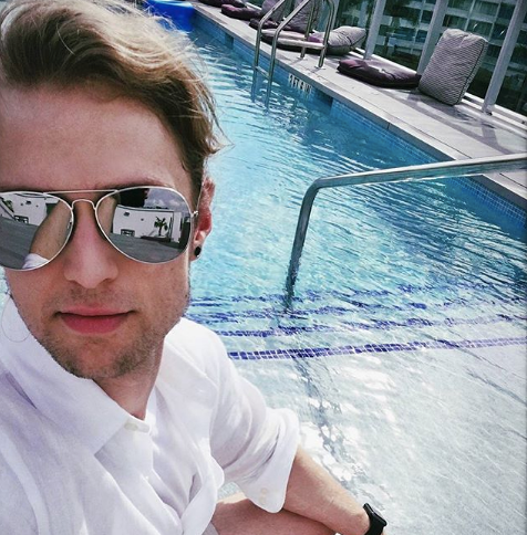 Writer Tyler Dårlig Ulv sits by the pool