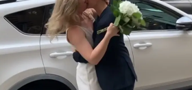 Lesbian couple gets married in the street as guests watch from parked cars & sidewalks