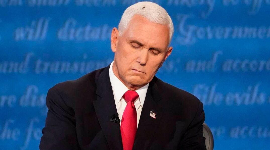 Mike Pence sitting at a table with his eyes closed.