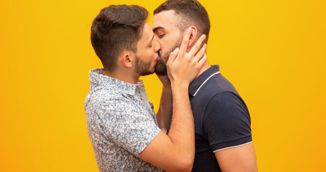 Two men share a kiss