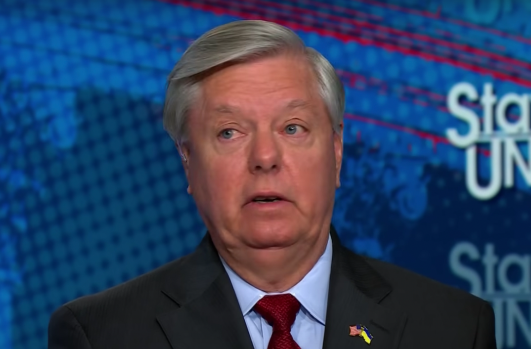 Lindsey Graham wearing a maroon tie looking to the side