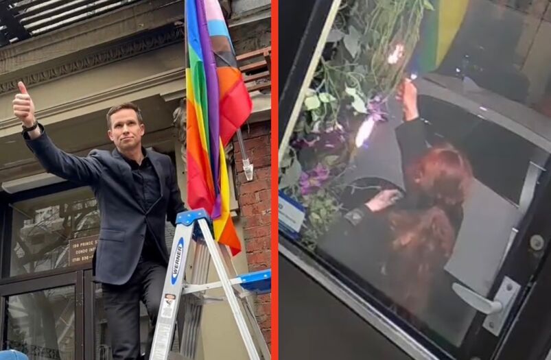NYC Council Member Erik Bottcher holds up the progress Pride flag replacing the Little Prince restaurant's previously burned flag.