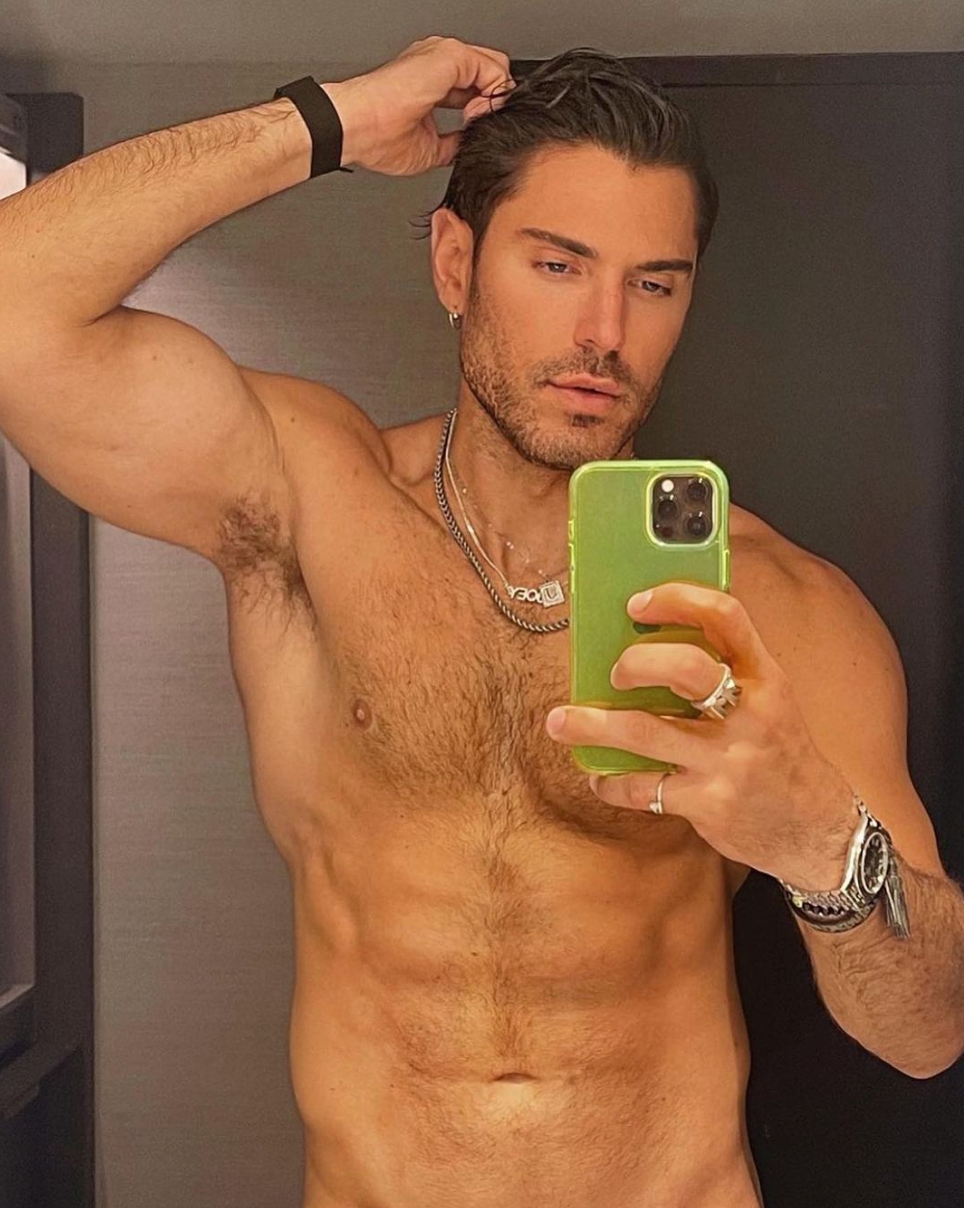 Joey Zauzig posing shirtless and taking a selfie.
