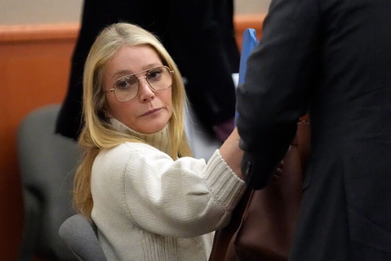 Gwyneth Paltrow in a white sweater and glasses looking unamused.