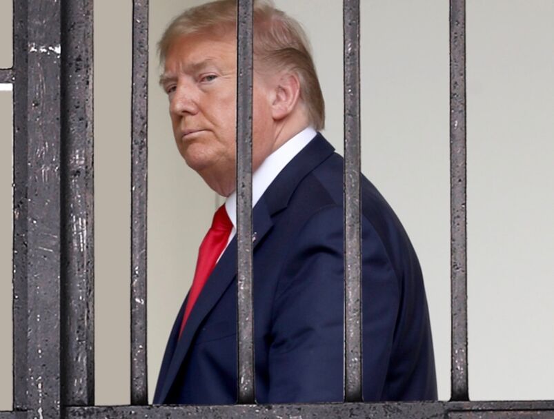 A graphic of Donald Trump standing behind fake prison bars.