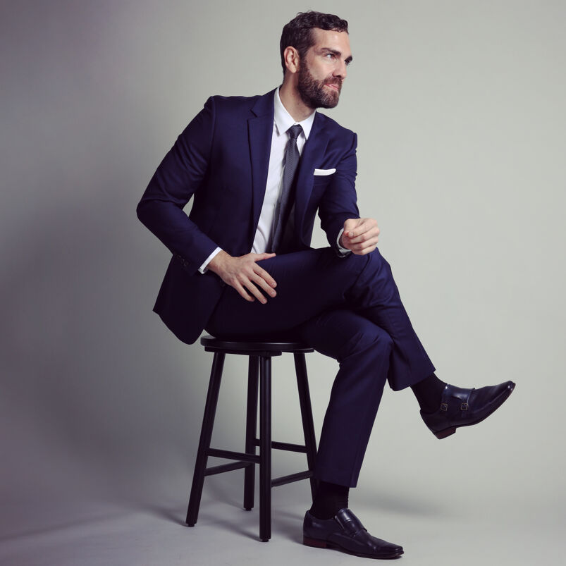 Broadway performer Timothy Hughes poses in a navy blue suit