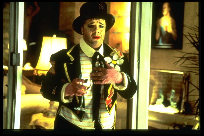 Nathan Lane wears clown makeup a tuxedo jacket and a top hot in a still from "The Birdcage'