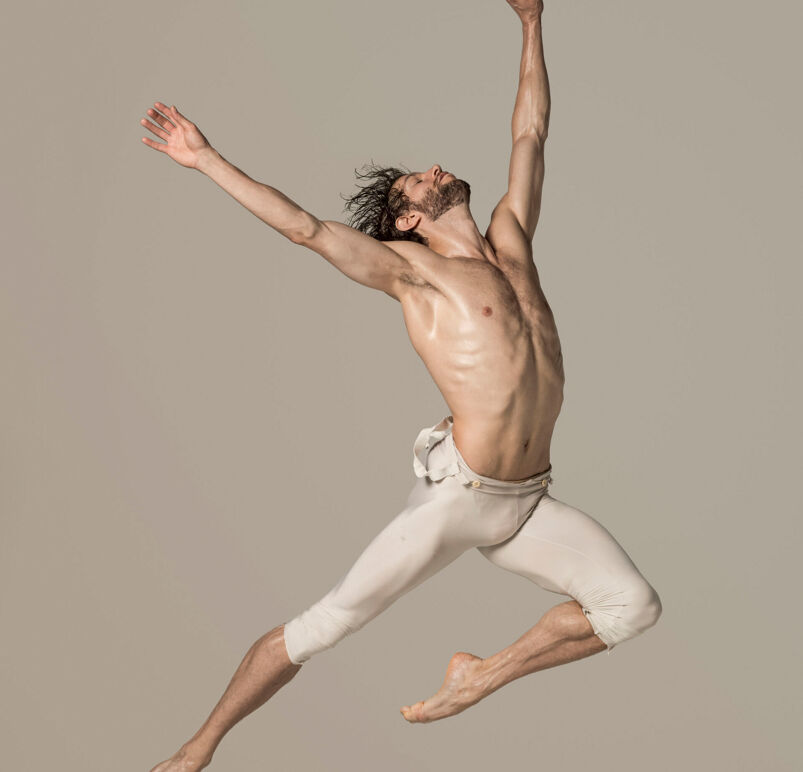 James Whiteside jumping shirtless in white tights.