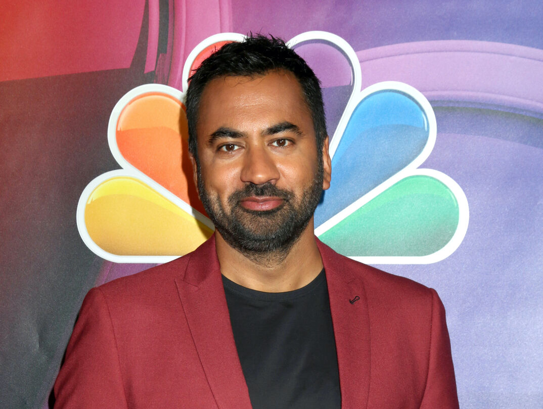 Kal Penn in a burgundy suit on the red carpet