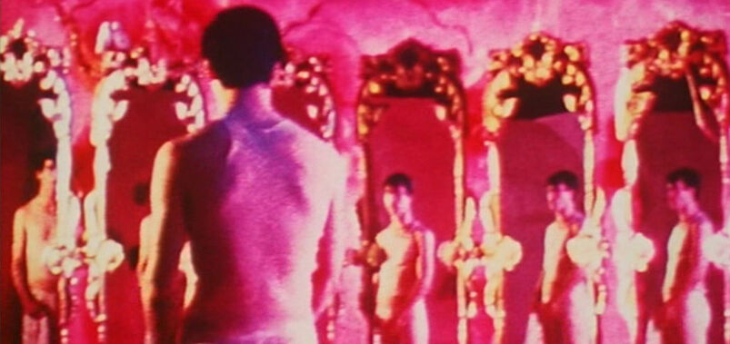 A still from 'Pink Narcissus' featuring a call-boy in pink standing in front of ornate gold mirrors