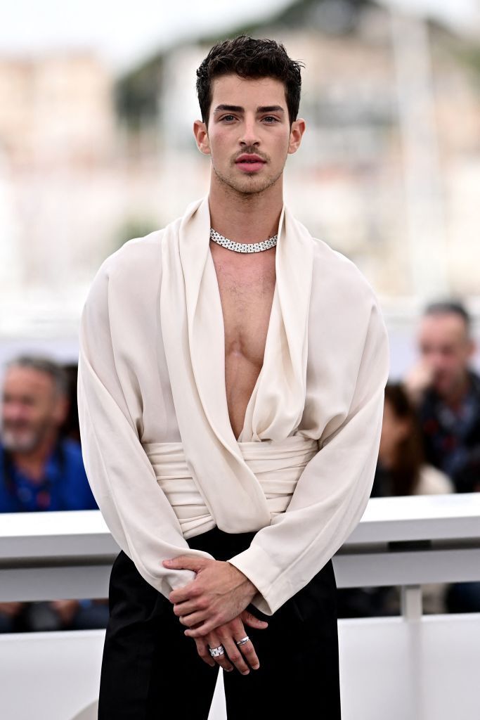 Manu Rios in a white plunging sweater on the red carpet