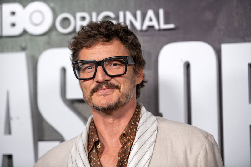 Pedro Pascal wearing glasses and a tan jacket