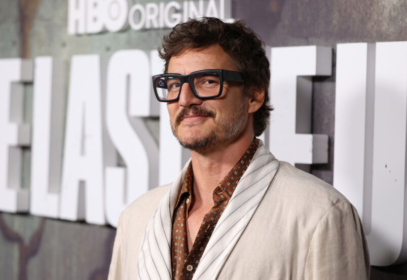 Pedro pascal wears glasses and poses on a red carpet for a 'The Last of Us' press event