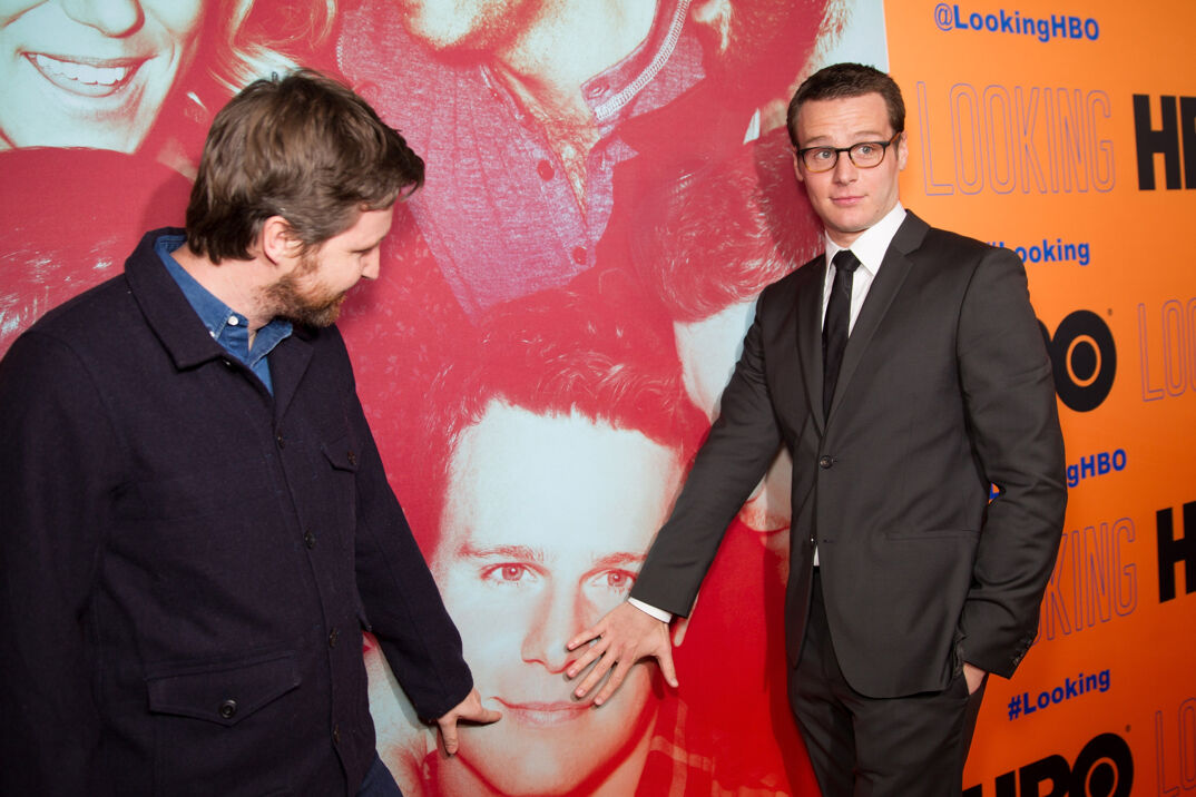 Andrew Haigh and Jonathan Groff touch a comically large poster of Groff's face on the red carpet for 'Looking.'