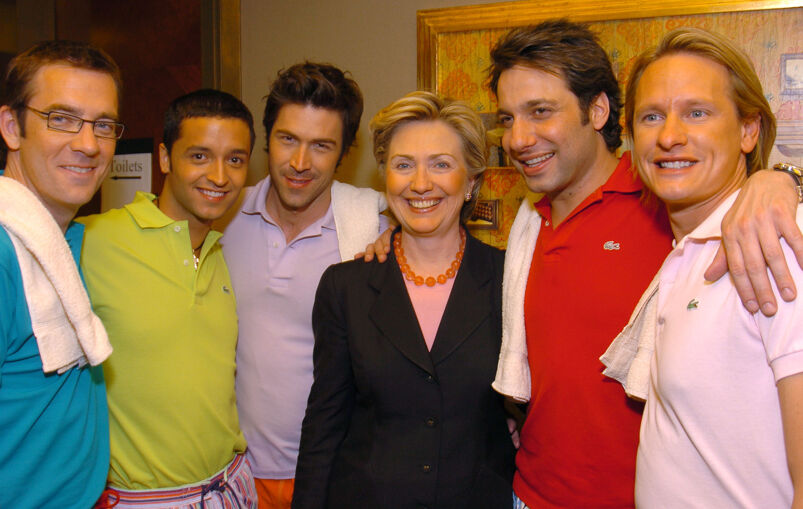 Ted Allen, Jai Rodriguez, Thom Filicia, Hillary Clinton, Kyan Douglas, and Carson Kressley smile and pose for a photo backstage at an event.