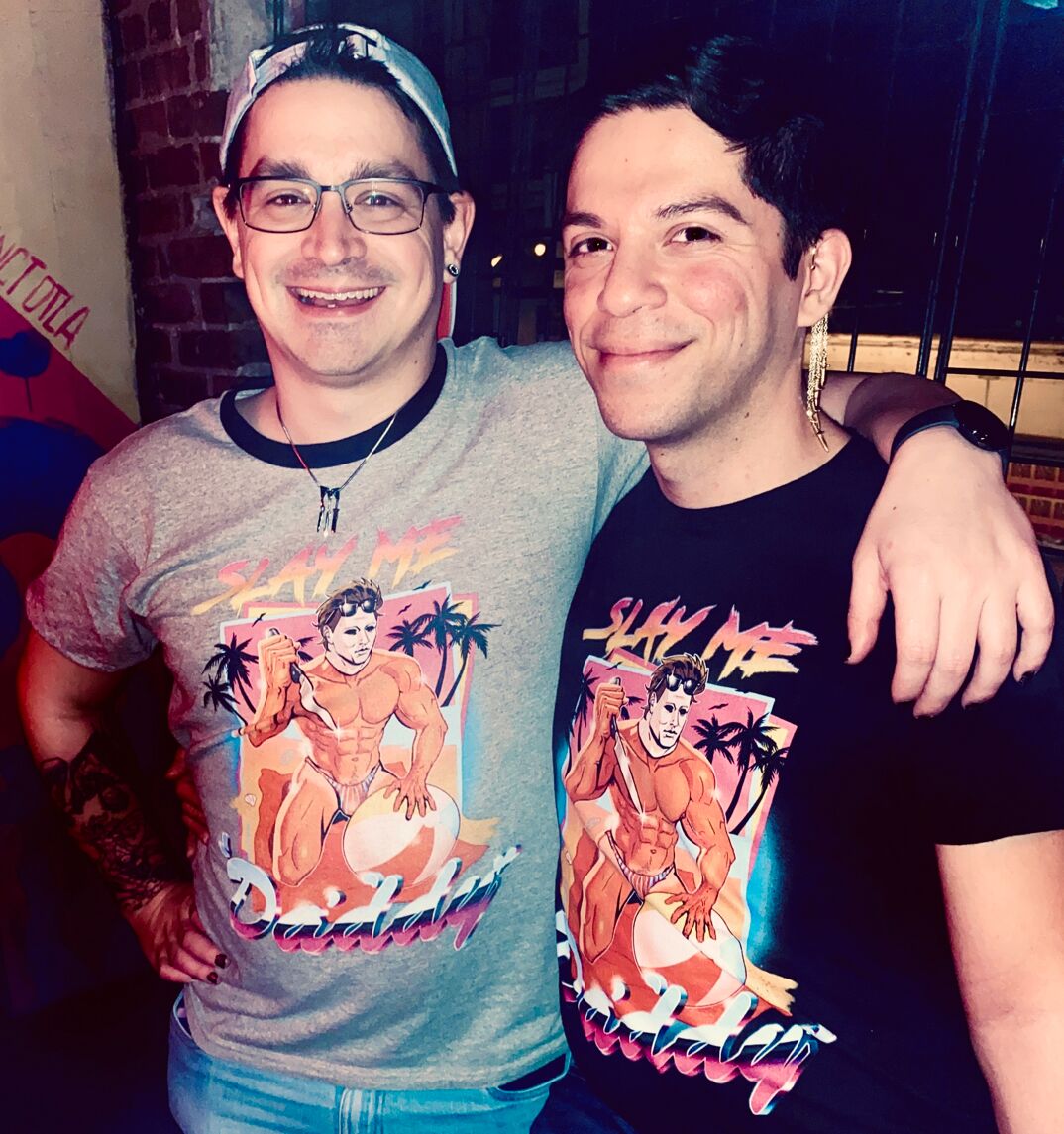Mario and Nick, a cute queer couple in matching "Slay Me Daddy" shirts.
