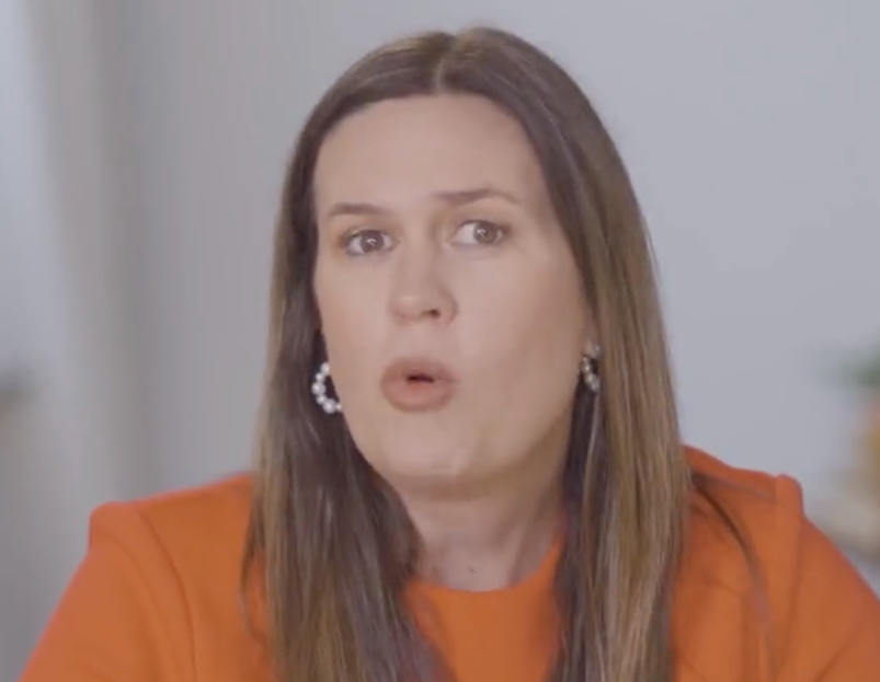 Sarah Huckabee Sanders in an orange shirt.