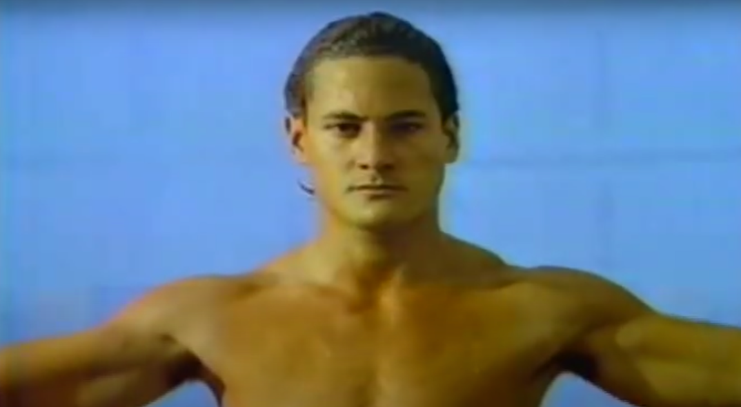 Greg Louganis from the early 1980s standing on top of a diving board.