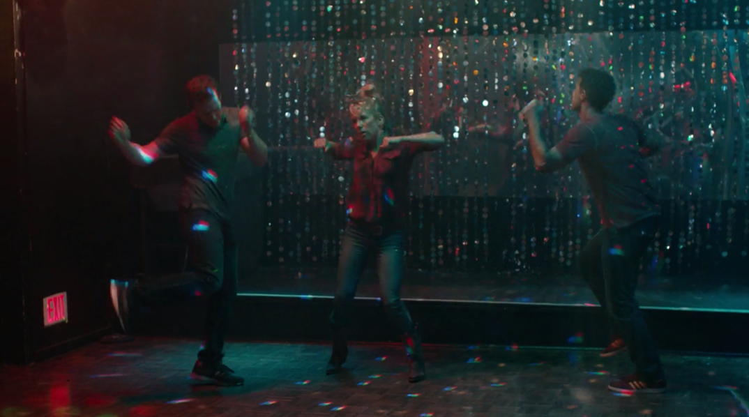 Jonathan Groff, Lauren Weedman, and Murray Bartlett dance like no one is watching on an empty gay club dance floor. 