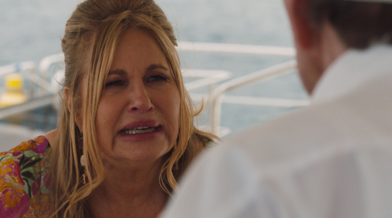 Actress Jennifer Coolidge looks distraught on a boat, talking to a man in a scene from HBO's 'The White Lotus.'