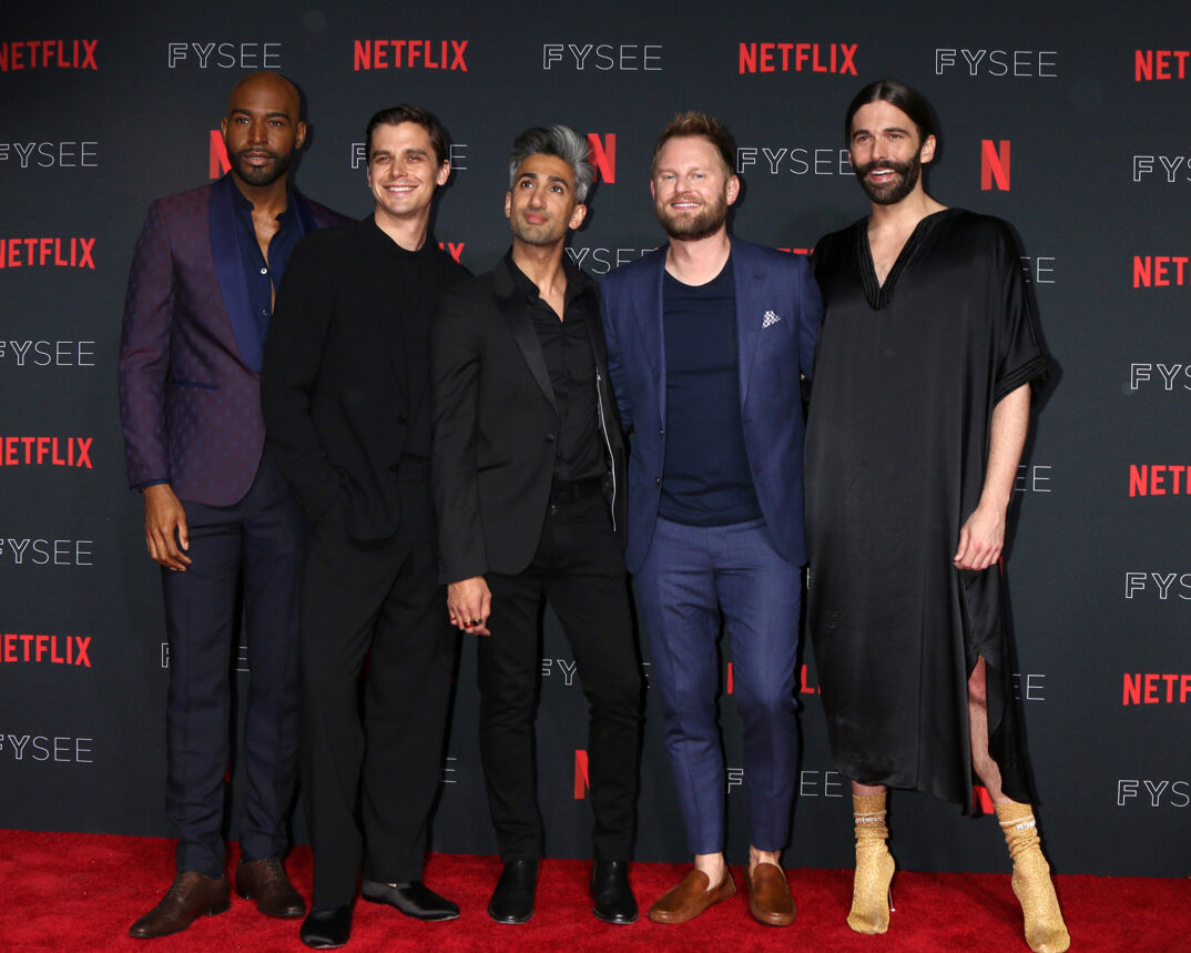 Karamo Brown, Antoni Porowski, Tan France, Bobby Berk, and Jonathan Van Ness smile at a Netflix red carpet event.
