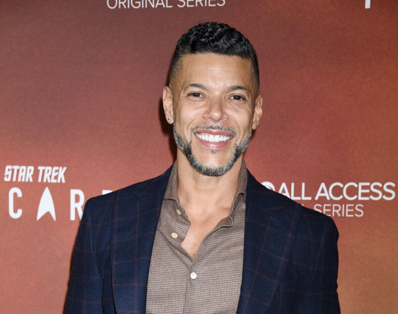 Wilson Cruz in a navy jacket on the red carpet