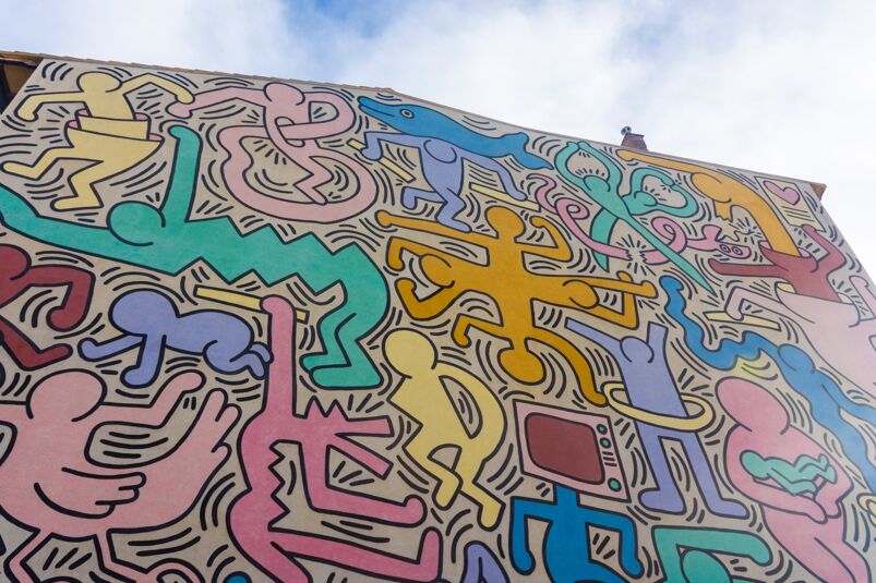 The side of a mural on a building painted by Keith Haring.