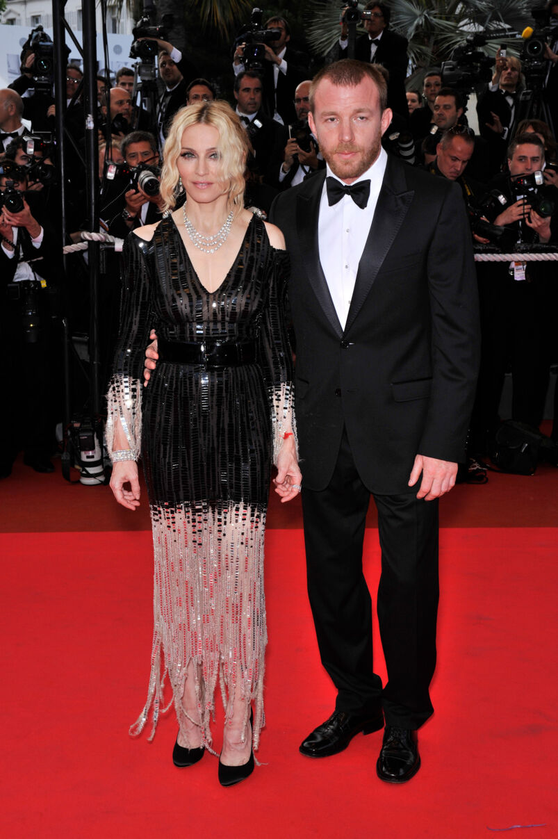 Madonna and Guy Ritchie, both dressed to the nines, pose on the red carpet in front of a sea of photographers.