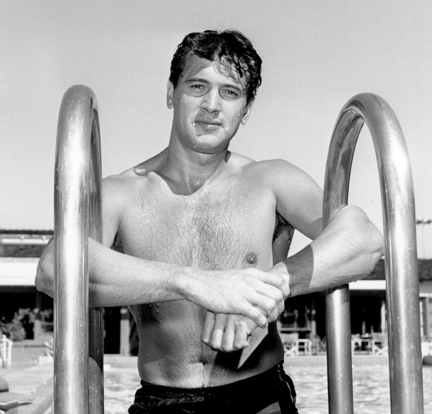 Rock Hudson in a swimsuit, emerging from a pool