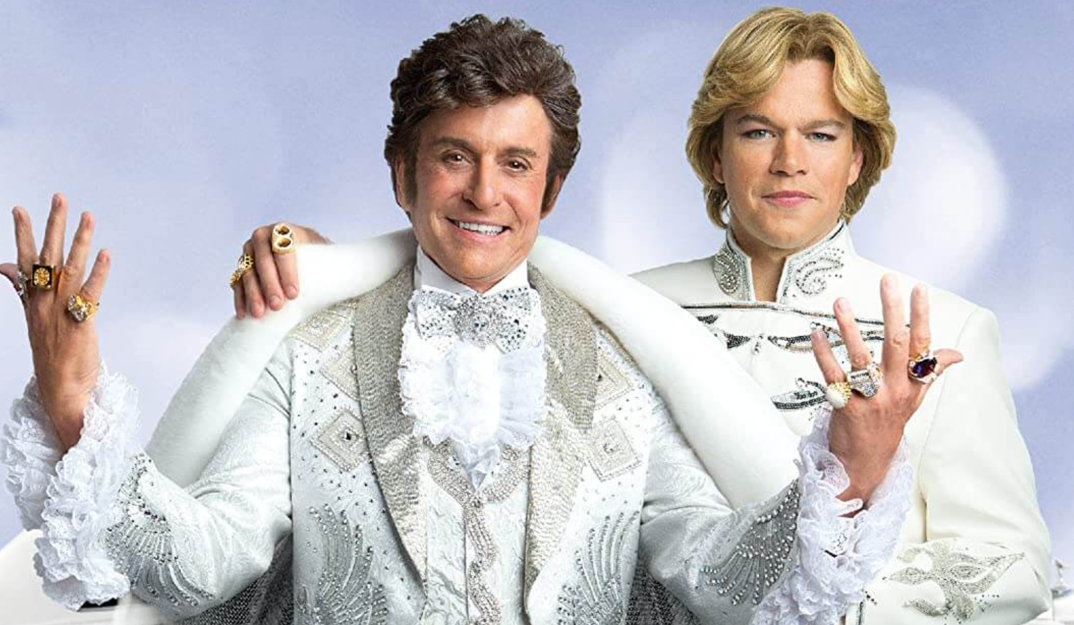 Michael Douglas, ridiculously dressed as Liberace with flamboyant rings and a sparkling white tuxedo, stands in front of an equally over-the-top dressed Matt Damon in the poster for 2013's 'Behind the Candelabra.'