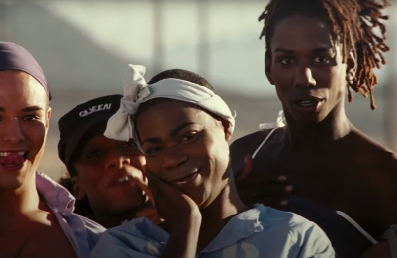 Tracy Morgan, wearing flamboyant makeup and a bonnet, looks suggestively at football players as Ms. Tucker in a scene from 2005's 'The Longest Yard.'