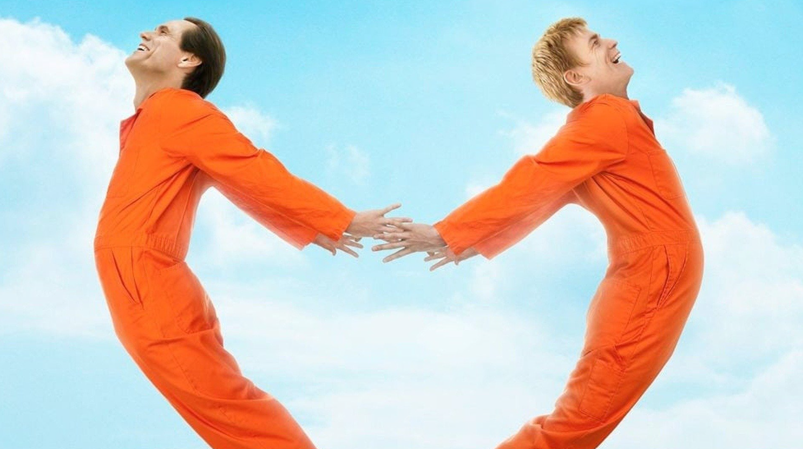 Jim Carrey and Ewan McGregor make the shape of a heart while jumping in the air, wearing orange prison jumpsuits, in a promotional photo for 'I Love You Phillip Morris.'