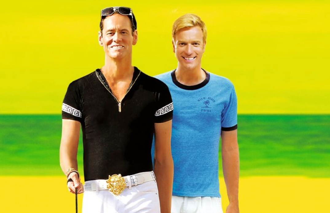 Jim Carrey, with slicked back hair and an over-the-top black V-neck, walks in front of a bleach blonde Ewan McGregor, smiling flamboyantly, in a promotional shot for 'I Love You Phillip Morris.'