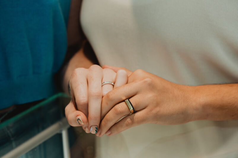 A female couple wears wedding bands by Shane Co.