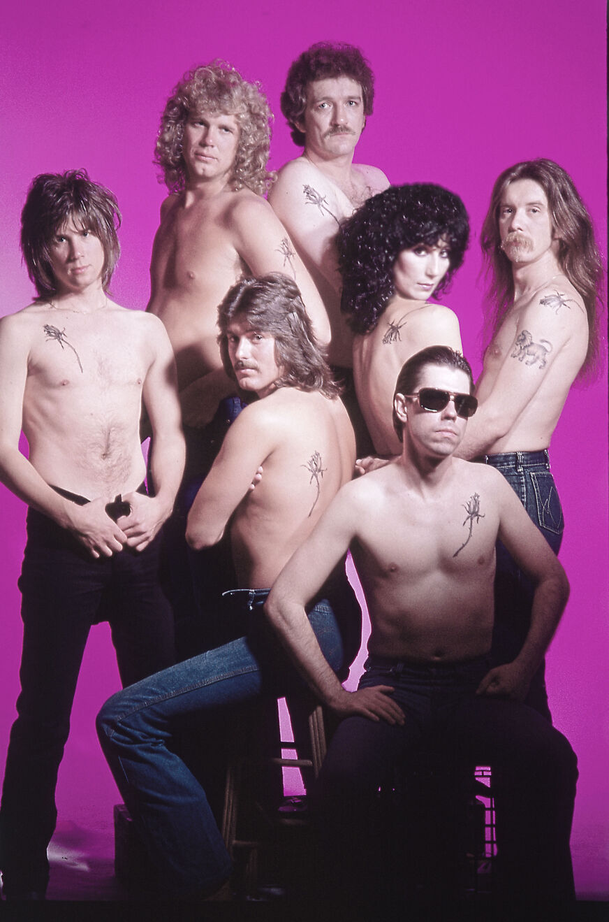 Cher poses nude with her band members from Black Rose in front of a purple background