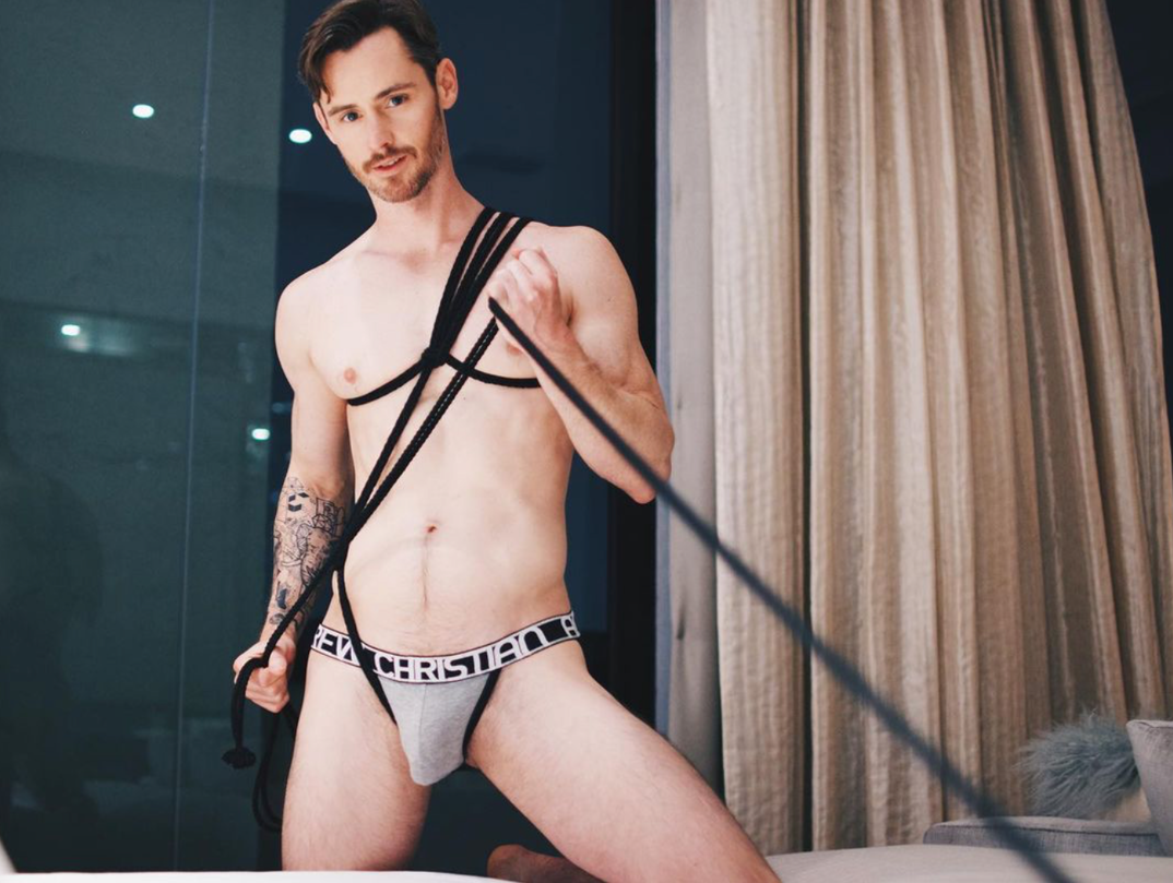 Dan Benson in Andrew Christian underwear holding rope