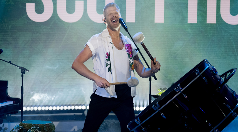 Scott Hoying performing in a white shirt with a big drum