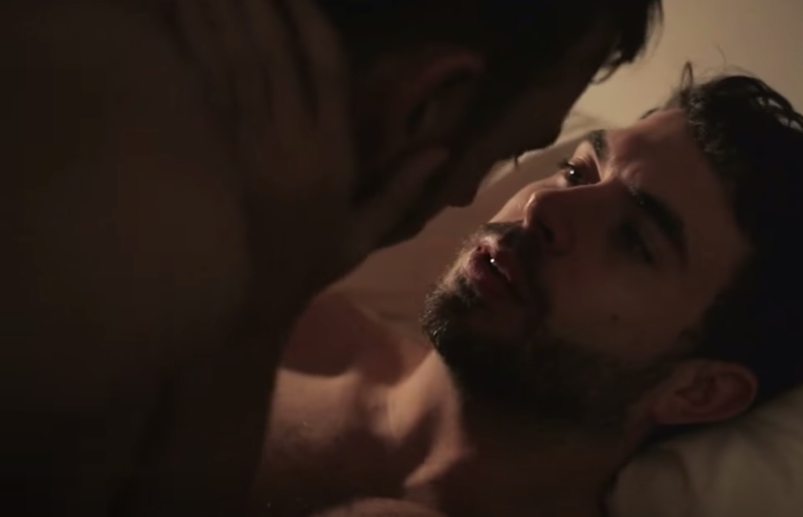 Tom Cullen looks up at Chris New with his hands on his face as they lay in a bed and have sex in a scene from 'Weekend.' All we can see are their vulnerable facial expressions.