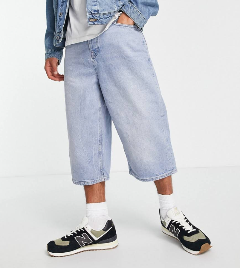 Joel Kim Booster in baggy jean shorts.