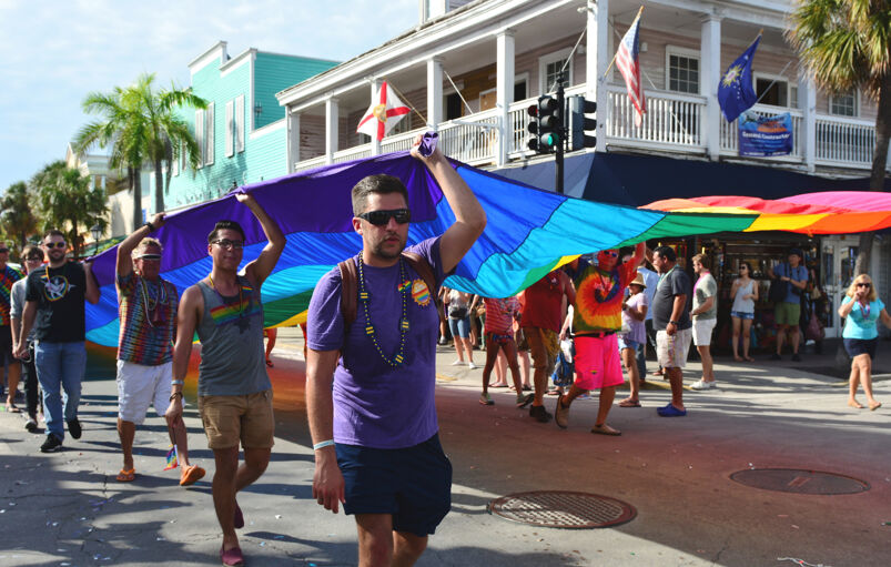 A group of people carrying the Pride Flag in Key West. 