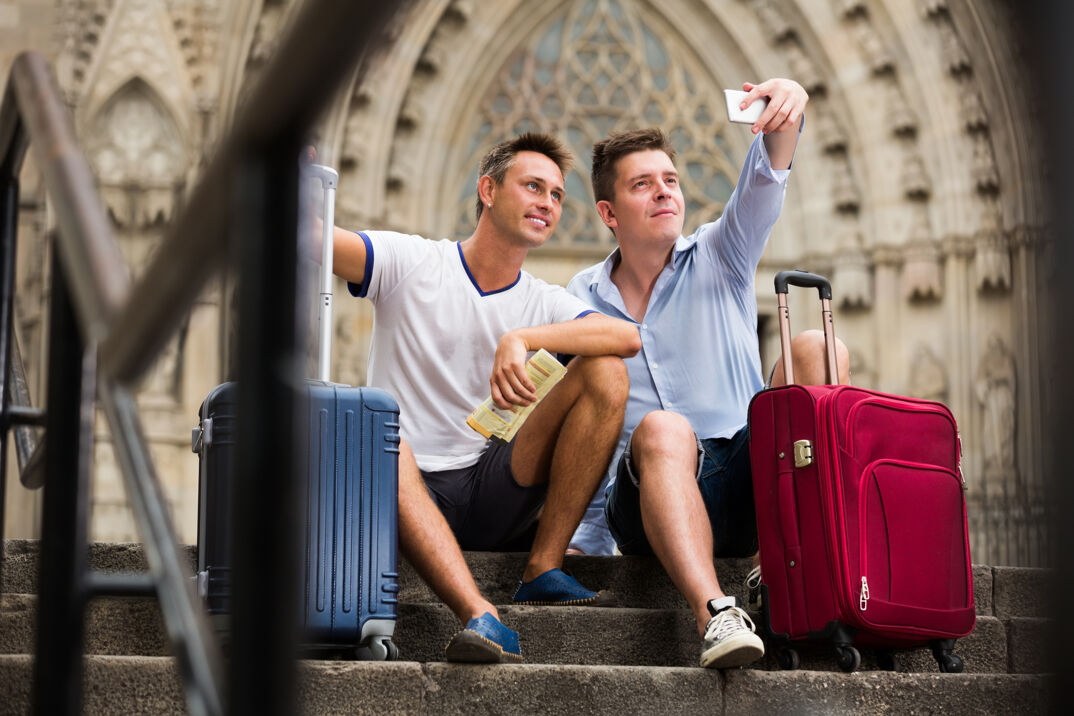 Two men taking a selfie at a train station. 