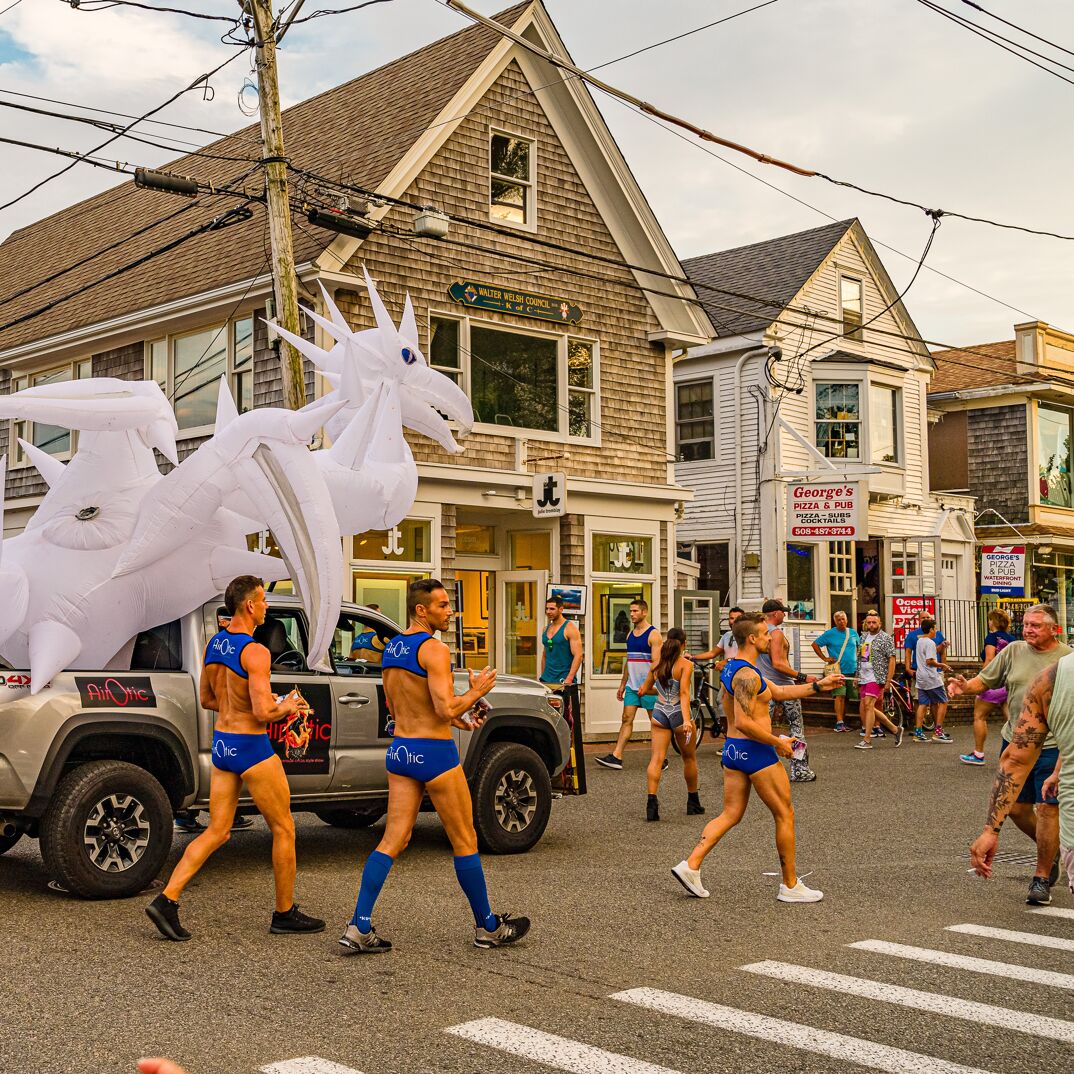 Gay men marching down Provincetown streets wearing minimal clothing