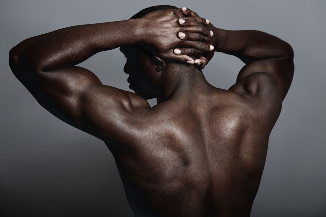 The muscular back of a Black man. 