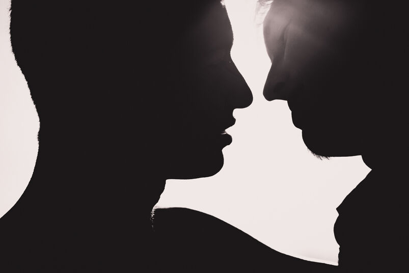 Two men kissing in silhouette