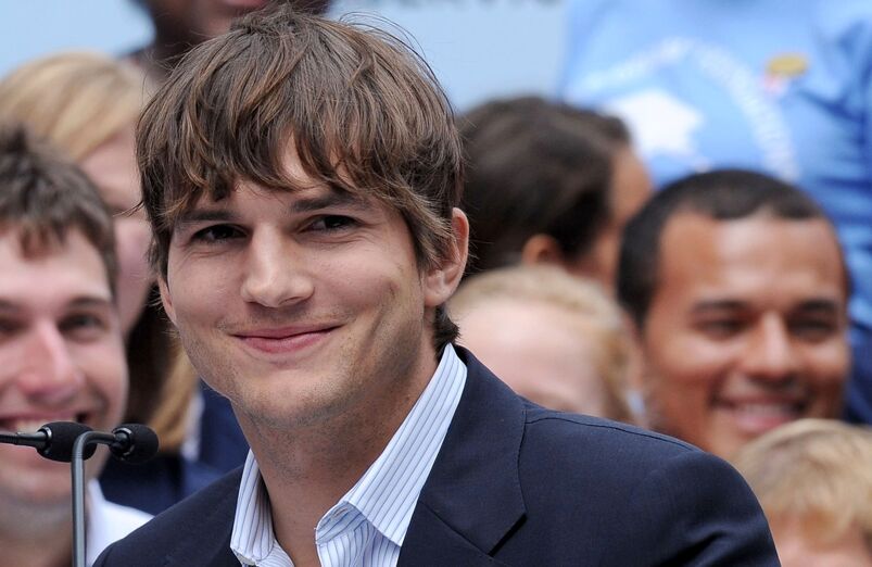 Smallest penises in Hollywood: Ashton Kutcher at the press conference for Entertainment Industry Foundation. He has a cheerful smile, disheveled brown hair, and is wearing a striped blue shirt and a blue blazer.